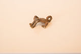 Side profile of a vintage copper frog charm showing its textured finish and hanging loop.