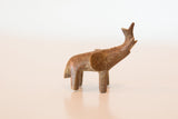 A vintage African copper elephant figurine in profile with a rustic, aged patina.