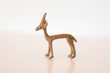 Vintage African copper gazelle casting with a textured, dusty patina viewed in profile.