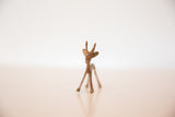A vintage African copper gazelle stands facing forward with a textured, dusty patina.