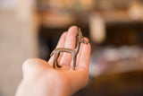 Vintage copper gazelle figurine held in hand to illustrate its small, collectible scale.