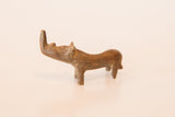 A vintage African copper rhino sculpture with a simple, curved form and a rustic patina.