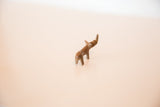 Vintage mini copper rhino sculpture viewed from a high angle, detailing its curved back.
