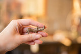 Small vintage copper rhino collectible held in a hand to show its scale.
