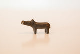 The simple, handmade form of a vintage dark copper hippo sculpture seen from the side.