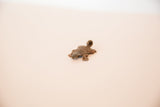 Vintage African copper turtle pendant shown from a high side angle.