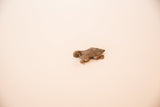 Angled view of the vintage copper turtle pendant highlighting its cast form and texture.