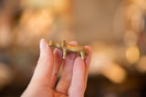 A small bronze hippo figurine with a golden patina held to show scale.