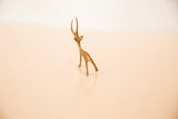 High-angle view of a miniature bronze gazelle, showing its slender back and horns.