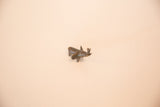 A vintage miniature African bronze sculpture of a stylized fish.