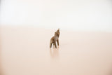 Rear angled view of the miniature cast bronze rhino's rustic, handmade body.