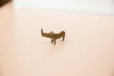 Bronze miniature rhinoceros with a curved back and visible aged patina.