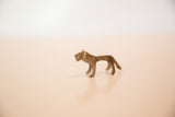 Side profile of a vintage African mini lion, detailing its aged, dusty bronze texture.