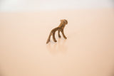 Collector's vintage bronze mini lion, highlighting its handmade texture and dusty patina.