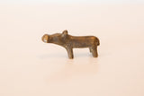 Profile view of a tiny vintage bronze hippo showing its aged patina.