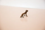 Vintage African miniature lion figurine, dark gold patina and textured bronze casting.