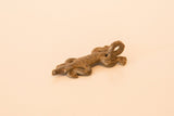 Detail of the cast bronze lizard charm showing the hanging loop and textured surface.
