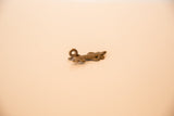 Profile view of the vintage African lizard pendant, showing its textured, cast bronze body.