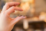 Profile view of a vintage African bronze turtle pendant showing its cast texture and scale.