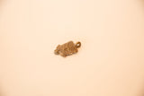A vintage bronze turtle pendant angled to show its cast texture and shape.