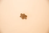 African bronze turtle pendant displaying a detailed flower design on its shell.