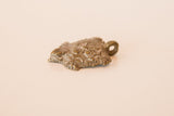 Angled view of the vintage bronze turtle pendant's textured shell with a dusty patina.
