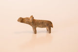 Side profile of a miniature bronze hippo showing its mottled, dusty patina.