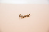 Side profile of the vintage bronze lizard pendant showing its handmade texture and aged patina.