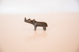 Vintage African miniature bronze rhino shown in profile with a textured patina.