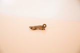 Side profile of the vintage bronze turtle pendant showing its cast texture.