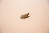 Angled view of a vintage cast bronze turtle pendant highlighting its textured shell.