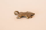 Angled view of a cast bronze turtle pendant highlighting its textured shell.