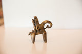 Side profile of vintage African bronze sculpture with intricate spirals and wrapped details, aged patina.