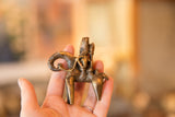 Detailed texture of the vintage bronze figure, showing animal's legs and warm patina.