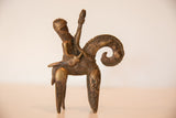 Vintage bronze warrior sculpture in profile, highlighting its rustic patina and the animal's curled tail.