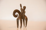 Three-quarter view of the vintage African bronze sculpture showing the rider's form.