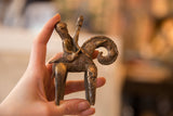 Vintage African bronze warrior sculpture held in hand, showing its scale and aged patina.