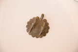 Two cast bronze crocodile figures atop a spiraled African medallion.