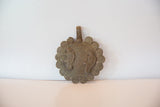 A vintage bronze chameleon medallion with aged patina, shown standing upright.