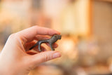 Vintage African mini bronze lion held in hand, showing its collectible size.