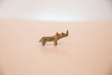 Profile view of the vintage African mini rhino's rustic, hand-cast form.