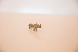 The small bronze rhino figurine with a dusty patina, viewed from an angle.