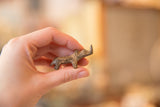 Handmade vintage bronze rhino held in hand to show its miniature, collectible scale.