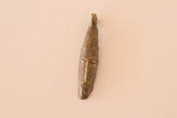 Elongated African bronze mask pendant with a ribbed surface texture.
