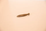 Side view of the vintage bronze mask pendant highlighting its textured, oxidized finish.