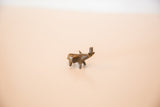 The aged patina and handmade form of a tiny African bronze elephant.