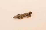 Angled view of a cast bronze lizard pendant with textured spots and a curved body.