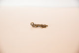 Side profile of the vintage bronze lizard pendant showing its cast depth and loop.