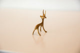 Rear angled view of a vintage bronze gazelle showing its slender, stylized form.