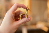 A small vintage bronze gazelle figurine held in hand to show its scale.